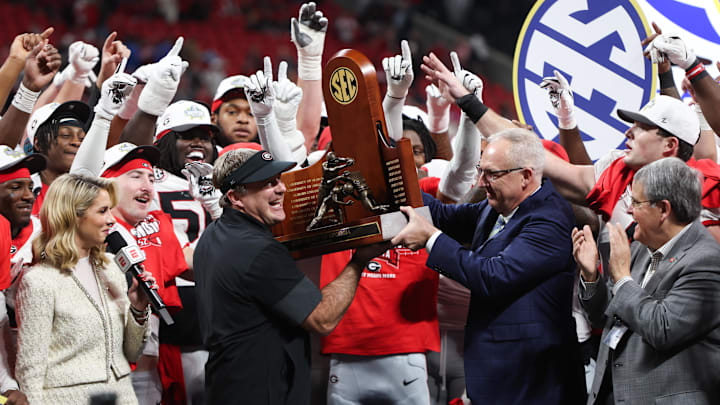 Dec 6, 2025; Atlanta, GA, USA; Georgia Bulldogs head coach Kirby Smart lifts the SEC Championship trophy after the game against the Alabama Crimson Tide during the 2025 SEC Championship game at Mercedes-Benz Stadium. Mandatory Credit: Brett Davis-Imagn Images Dec 6, 2025; Atlanta, GA, USA; Georgia Bulldogs head coach Kirby Smart lifts the SEC Championship trophy after the game against the Alabama Crimson Tide during the 2025 SEC Championship game at Mercedes-Benz Stadium. Mandatory Credit: Brett Davis-Imagn Images