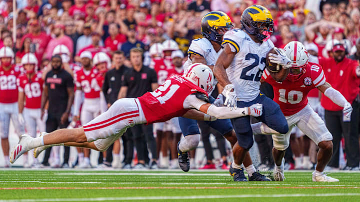 Sep 20, 2025; Lincoln, Nebraska, USA; Michigan Wolverines running back Jordan Marshall (23) is tackled by Nebraska Cornhuskers defensive back Andrew Marshall (10) and defensive back Rex Guthrie (21) during the fourth quarter at Memorial Stadium. 