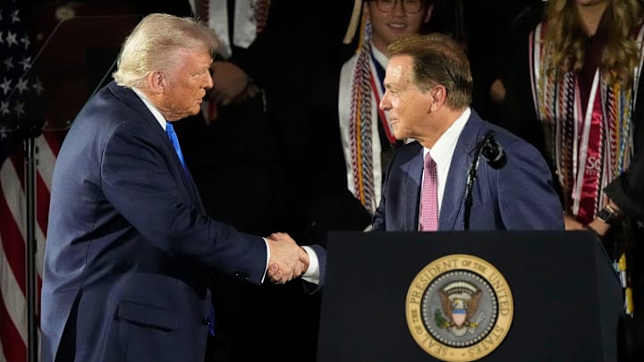 Trump shakes hands with Saban before delivering a commencement address to University of Alabama graduates.