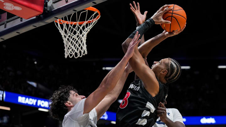 Dec 5, 2025; Cincinnati, Ohio, USA;  Cincinnati Bearcats forward Baba Miller (18) drives to the basket against Xavier Musketeers forward Jovan Milicevic (24) and forward Pape N'Diaye (22) in the second half at the Cintas Center. Mandatory Credit: Aaron Doster-Imagn Images