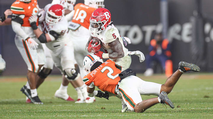 Dec 28, 2023; Bronx, NY, USA; Rutgers Scarlet Knights running back Kyle Monangai (5) is tackled by Miami Hurricanes defensive back Daryl Porter Jr. (2) during the second half of the 2023 Pinstripe Bowl at Yankee Stadium. 