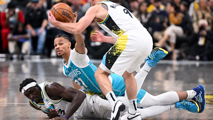 Dec 8, 2024; Indianapolis, Indiana, USA; Charlotte Hornets guard Isaiah Wong (21) tips a loose ball away from Indiana Pacers guard T.J. McConnell (9) during the first half at Gainbridge Fieldhouse. Mandatory Credit: Robert Goddin-Imagn Images 