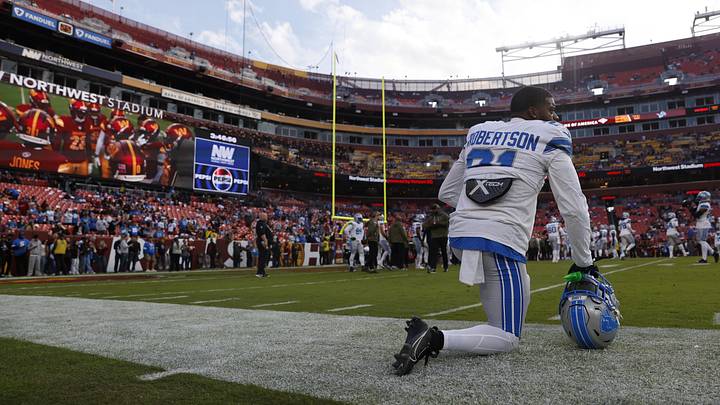 Nov 9, 2025; Landover, Maryland, USA; Detroit Lions cornerback Amik Robertson (21) kneels on the field during warmups prior to a game against the Washington Commanders at Northwest Stadium. Mandatory Credit: Peter Casey-Imagn Images