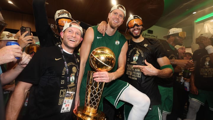 Jun 17, 2024; Boston, Massachusetts, USA; Boston Celtics center Kristaps Porzingis (center) and forward Jayson Tatum (right) celebrate with Celtics director of rehabilitation Steve Mount in the locker room after winning the 2024 NBA Finals against the Dallas Mavericks at TD Garden. Mandatory Credit: Elsa/Pool Photo-USA TODAY Sports