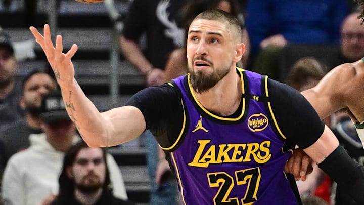 Mar 13, 2025; Milwaukee, Wisconsin, USA; Los Angeles Lakers center Alex Len (27) reaches for the ball against Milwaukee Bucks center Jericho Sims (00) in the second quarter at Fiserv Forum. Mandatory Credit: Benny Sieu-Imagn Images