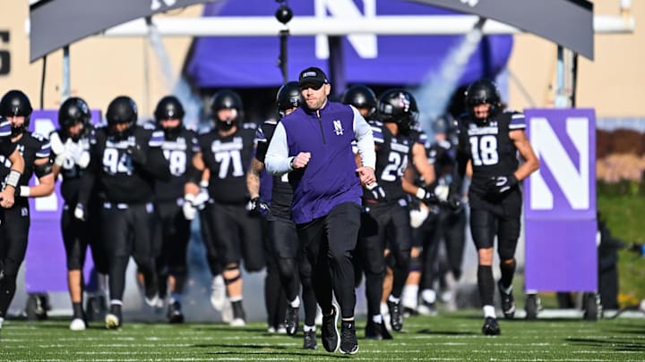 Nov 18, 2023; Evanston, Illinois, USA;  Northwestern Wildcats head coach David Braun leads his team onto the field before a game against the Purdue Boilermakers at Ryan Field. Mandatory Credit: Jamie Sabau-Imagn Images
