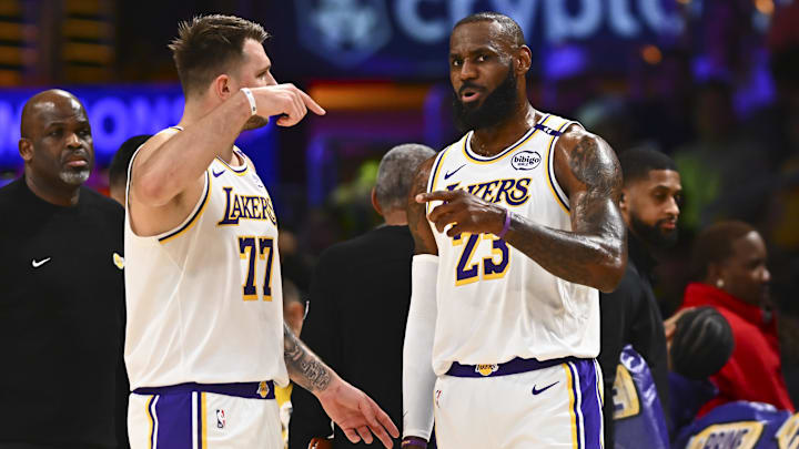 Mar 22, 2025; Los Angeles, California, USA; Los Angeles Lakers guard Luka Doncic (77) and Los Angeles Lakers forward LeBron James (23) on the sidelines against the Chicago Bulls during the first half at Crypto.com Arena. Mandatory Credit: Jonathan Hui-Imagn Images