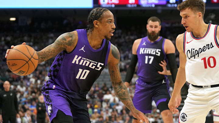 Apr 11, 2025; Sacramento, California, USA; Sacramento Kings forward DeMar DeRozan (left) dribbles against Los Angeles Clippers guard Bogdan Bogdanovic (right) during the first quarter at Golden 1 Center. Mandatory Credit: Darren Yamashita-Imagn Images