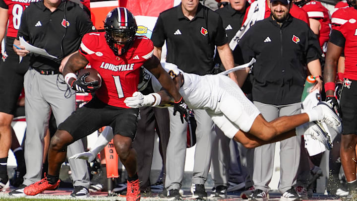 Louisville Cardinals running back Isaac Brown (1) avoids a tackle after a reception against the Toledo Rockets