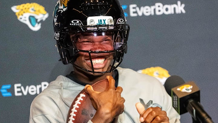 The Jacksonville Jaguars’ first-round pick, Colorado Buffaloes wide receiver and defensive back Travis Hunter sits in his chair with his helmet on and acting as if he was running after answering questions during a press conference. The Jacksonville Jaguars’ first-round pick, Colorado Buffaloes wide receiver and defensive back Travis Hunter sits in his chair with his helmet on and acting as if he was running after answering questions during a press conference.