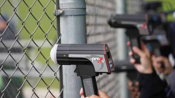 Scouts with radar guns clocking velocity of pitching prospects