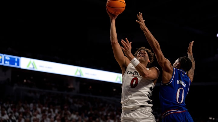 Cincinnati Bearcats guard Dan Skillings Jr. (0) hits a shot around Kansas Jayhawks guard Shakeel Moore (0) in the second half of the NCAA basketball game at Fifth Third Arena in Cincinnati on Saturday, January 11, 2025.