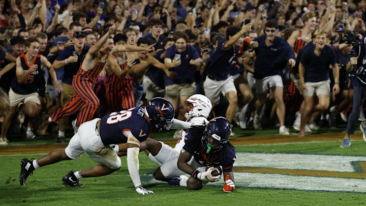 Sep 26, 2025; Charlottesville, Virginia, USA; Virginia Cavaliers defensive back Ja'son Prevard (10) is hugged by Cavaliers defensive back Donavon Platt (28) as fans storm the field after making a game winning interception in the end zone on a pass intended for Florida State Seminoles wide receiver Squirrel White (4) in the second overtime at Scott Stadium. Mandatory Credit: Geoff Burke-Imagn Images