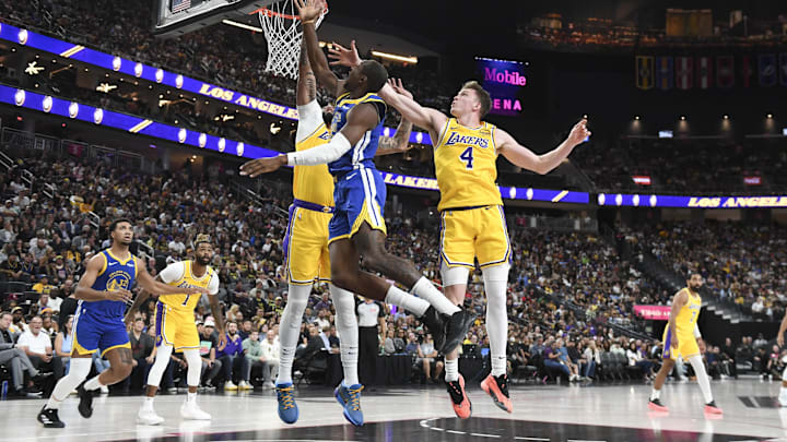 Oct 15, 2024; Las Vegas, Nevada, USA; Golden State Warriors forward Jonathan Kuminga (00) shoots against Los Angeles Lakers center Anthony Davis (3) and guard Dalton Knecht (4) in the second quarter during a preseason game at T-Mobile Arena. Mandatory Credit: Candice Ward-Imagn Images