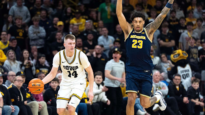 Iowa guard Bennett Stirtz (14) dribbles down court against Michigan forward Yaxel Lendeborg (23)