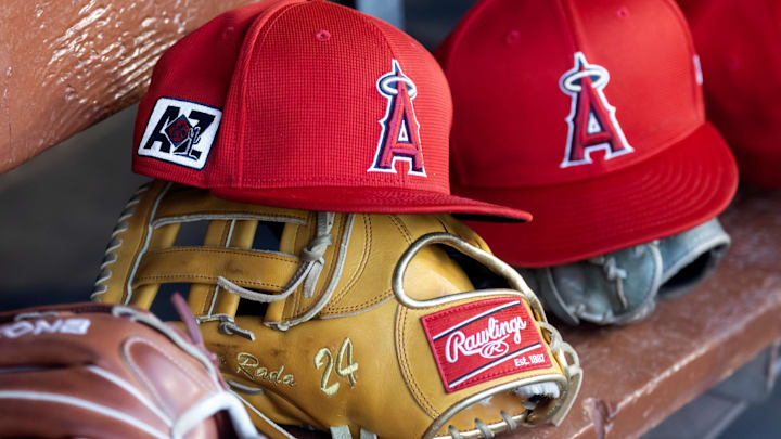 Feb 28, 2025; Phoenix, Arizona, USA; Detailed view of the Los Angeles Angels logo on a hat in the dugout during a spring training game at Camelback Ranch-Glendale. Mandatory Credit: Mark J. Rebilas-Imagn Images