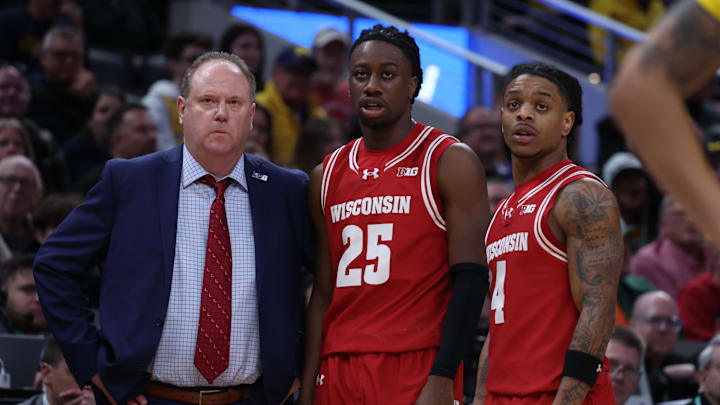 Mar 16, 2025; Indianapolis, IN, USA; Wisconsin Badgers head coach Greg Gard, guard John Blackwell (25) and guard Kamari McGee (4) talk during a pause in play during the second half against the Michigan Wolverines during the 2025 Big Ten Championship Game at Gainbridge Fieldhouse.