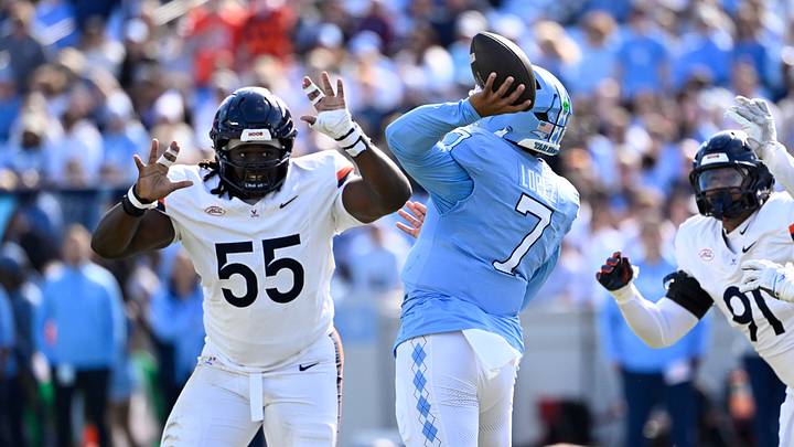 Oct 25, 2025; Chapel Hill, North Carolina, USA; North Carolina Tar Heels quarterback Gio Lopez (7) passes the ball as Virginia Cavaliers defensive tackles Anthony Britton (55) and Jason Hammond (91) pressure in the first quarter at Kenan Stadium. Mandatory Credit: Bob Donnan-Imagn Images Oct 25, 2025; Chapel Hill, North Carolina, USA; North Carolina Tar Heels quarterback Gio Lopez (7) passes the ball as Virginia Cavaliers defensive tackles Anthony Britton (55) and Jason Hammond (91) pressure in the first quarter at Kenan Stadium. Mandatory Credit: Bob Donnan-Imagn Images