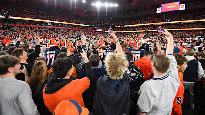 Nov 30, 2024; Syracuse, New York, USA; Syracuse Orange fans celebrate on the field following a game against the Miami Hurricanes at the JMA Wireless Dome. Mandatory Credit: Rich Barnes-Imagn Images