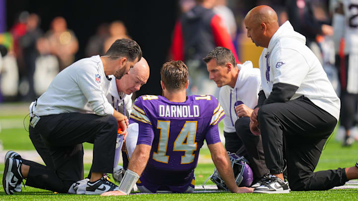 Minnesota Vikings quarterback Sam Darnold is checked by medical staff after injuring his knee.
