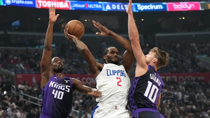 LA Clippers forward Kawhi Leonard (2) passes the ball against Sacramento Kings forward Harrison Barnes (40) and forward Domantas Sabonis (10) in the first half at Crypto.com Arena. Mandatory Credit: Kirby Lee-Imagn Images