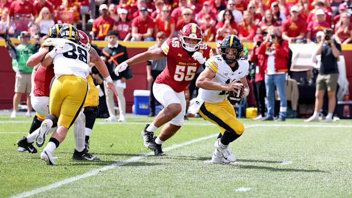 Sep 6, 2025; Ames, Iowa, USA; Iowa Hawkeyes quarterback Mark Gronowski (11) scrambles under pressure from Iowa State Cyclones defensive lineman Jace J. Gilbert (55) during the second half at Jack Trice Stadium. Mandatory Credit: Reese Strickland-Imagn Images