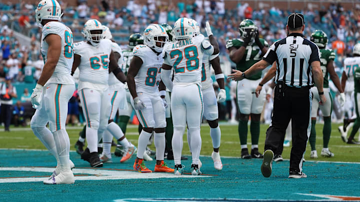 Miami Dolphins running back De'Von Achane (28) celebrates his touchdown against the New York Jets with teammates during the first half at Hard Rock Stadium in Week 14.
