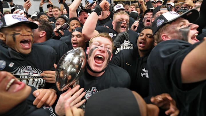 Army Black Knights safety Max DiDomenico (6) celebrates in the locker room with the American Athletic Conference trophy after a 35-14 win against the Tulane Green Wave at Michie Stadium.  