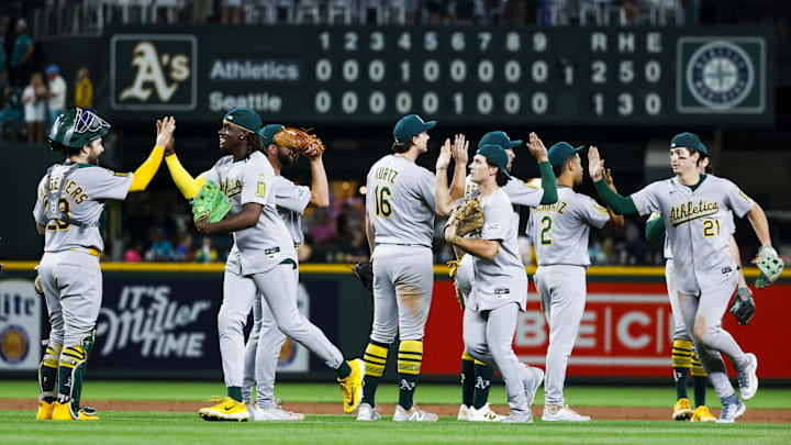 Aug 23, 2025; Seattle, Washington, USA; Athletics players, including catcher Shea Langeliers (23, left) center fielder Lawrence Butler (4, second from left) first baseman Nick Kurtz (16), right fielder Carlos Cortes (26, fourth from right), second baseman Darell Hernaiz (2) and left fielder Tyler Soderstrom (21) exchange high-fives following a ten-inning victory against the Seattle Mariners at T-Mobile Park. Mandatory Credit: Joe Nicholson-Imagn Images