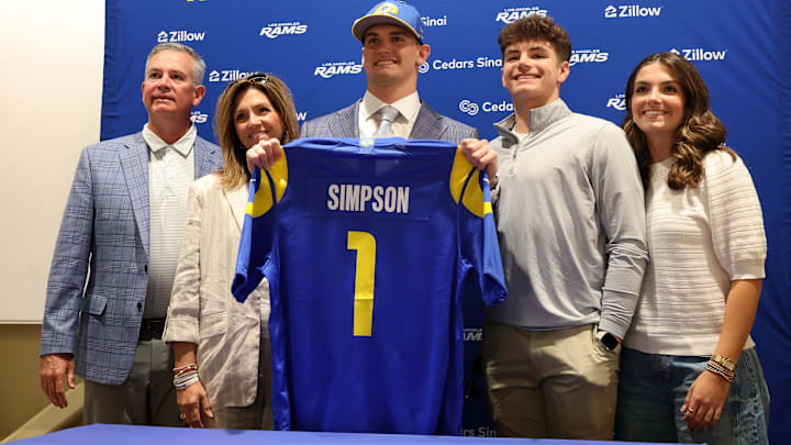 Los Angeles Rams first-round draft pick Ty Simpson holds his jersey with his family.