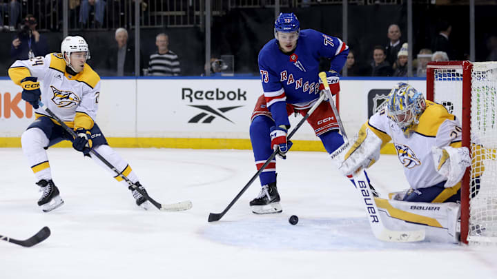 Mar 2, 2025; New York, New York, USA; New York Rangers center Matt Rempe (73) plays the puck against Nashville Predators goaltender Justus Annunen (29) and defenseman Spencer Stastney (24) during the second period at Madison Square Garden. Mandatory Credit: Brad Penner-Imagn Images
