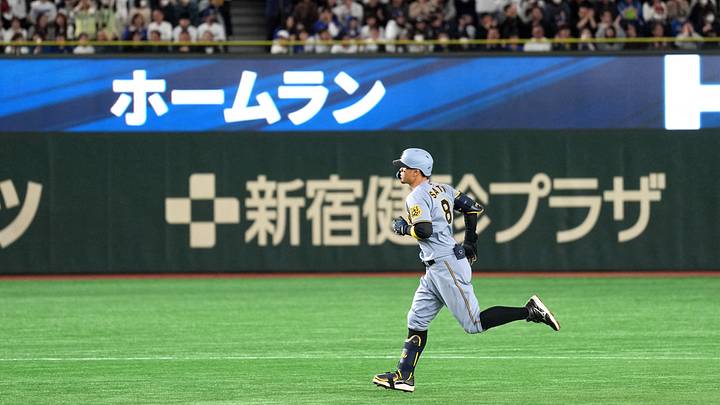 Mar 16, 2025; Bunkyo, Tokyo, Japan; Hanshin Tigers third baseman Teruaki Sato (8) rounds the bases after hitting a home run against the Los Angeles Dodgers as home run is displayed in Japanese on the message board during the fourth inning at Tokyo Dome. Mandatory Credit: Darren Yamashita-Imagn Images