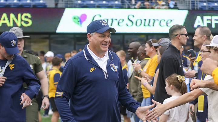 Sep 27, 2025; Morgantown, West Virginia, USA; West Virginia Mountaineers head coach Rich Rodriguez walks on the field and greets fans before their game against the Utah Utes at Milan Puskar Stadium. Mandatory Credit: Ben Queen-Imagn Images
