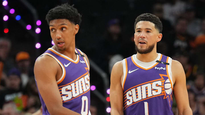 Nov 6, 2024; Phoenix, Arizona, USA; Phoenix Suns forward Ryan Dunn (0) and Phoenix Suns guard Devin Booker (1) look on against the Miami Heat during the first half at Footprint Center. Mandatory Credit: Joe Camporeale-Imagn Images