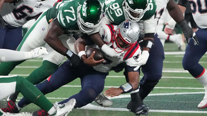 Sep 19, 2024; East Rutherford, New Jersey, USA;  New England Patriots quarterback Jacoby Brissett (7) sacked by New York Jets defensive end Micheal Clemons (72)  and  defensive end Will McDonald IV (99)  in the 1st half at MetLife Stadium. Mandatory Credit: Robert Deutsch-Imagn Images