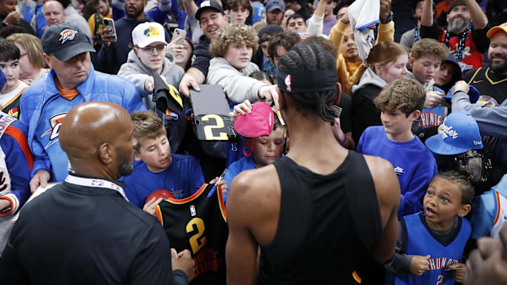 Apr 6, 2025; Oklahoma City, Oklahoma, USA; Basketball fans get autographs from Oklahoma City Thunder guard Shai Gilgeous-Alexander before the start of a game against the Los Angeles Lakers at Paycom Center. Mandatory Credit: Alonzo Adams-Imagn Images