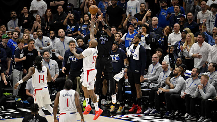 Dallas Mavericks guard Kyrie Irving (11) makes a three point shot and is fouled by LA Clippers forward P.J. Tucker (17) during the first round of the 2024 NBA playoffs.