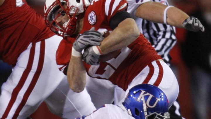Nebraska Cornhuskers running back is tackled by Kansas defender