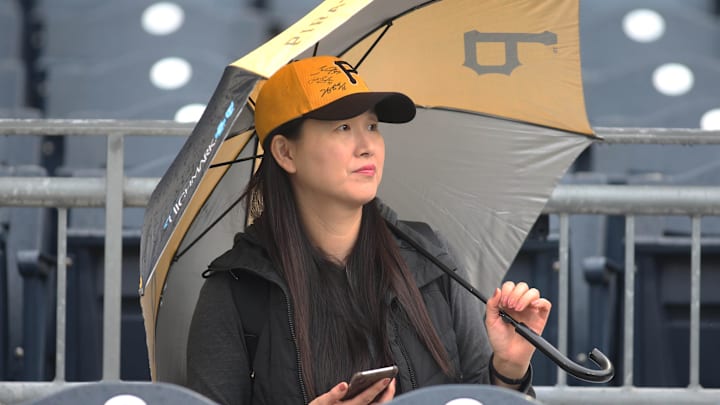 Apr 19, 2019; Pittsburgh, PA, USA;  Pittsburgh Pirates fan Sun Seo looks on as rain falls before the Pirates host the San Francisco Giants at PNC Park. Seo is hoping for the opportunity to watch Pittsburgh Pirates third baseman Jung Ho Kang (not pictured) in action. Mandatory Credit: Charles LeClaire-Imagn Images
