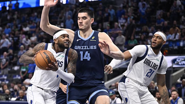 Oct 7, 2024; Dallas, Texas, USA; Dallas Mavericks guard Jaden Hardy (1) drives to the basket past Memphis Grizzlies center Zach Edey (14) as center Daniel Gafford (21) looks on during the first quarter at the American Airlines Center. Mandatory Credit: Jerome Miron-Imagn Images