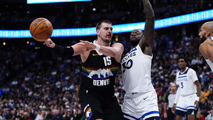 Dec 25, 2025; Denver, Colorado, USA; Denver Nuggets center Nikola Jokic (15) passes the ball away from Minnesota Timberwolves forward Julius Randle (30) in overtime at Ball Arena. Mandatory Credit: Ron Chenoy-Imagn Images