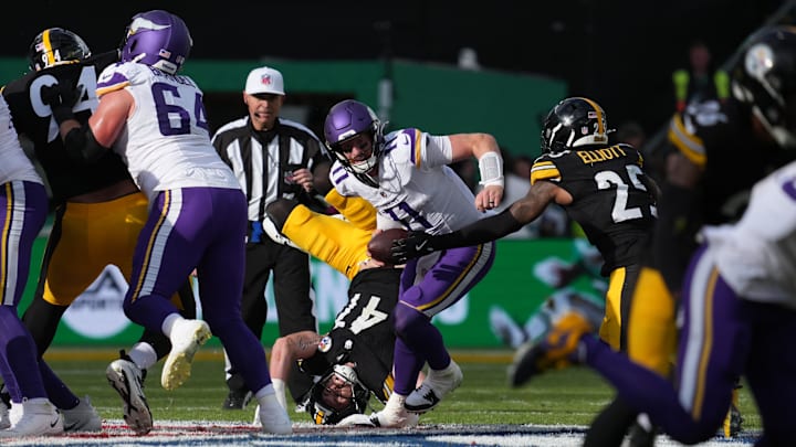 Sep 28, 2025; Dublin, Ireland; Minnesota Vikings quarterback Carson Wentz (11) moves around the pocket under pressure from Pittsburgh Steelers linebacker Payton Wilson (41) and safety Deshon Elliott (25) during the third quarter during an NFL International Series game at Croke Park. Mandatory Credit: Kirby Lee-Imagn Images