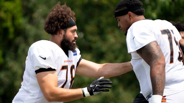 Cincinnati Bengals offensive tackle Devin Cochran (76) and Cincinnati Bengals offensive tackle Orlando Brown Jr. (75) perform a offensive line drill at Cincinnati Bengals training camp on the Kettering Health Practice Fields in Cincinnati on Sunday, Aug. 4, 2024.