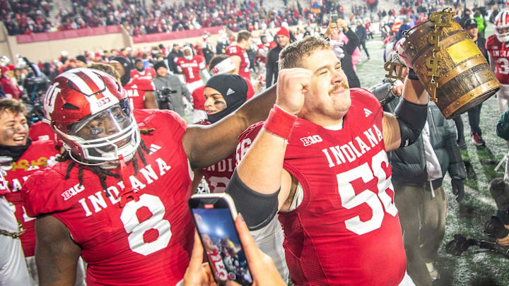 Indiana's Mike Katic (56) and CJ West (8) celebrate with the Old Oaken Bucket after the Indiana versus Purdue football game at Memorial Stadium on Saturday, Nov. 30, 2024.