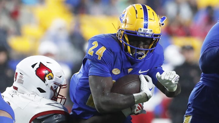 Oct 14, 2023; Pittsburgh, Pennsylvania, USA; Pittsburgh Panthers running back C'Bo Flemister (24) runs with the ball against Louisville Cardinals defensive lineman Dezmond Tell (99) during the third quarter at Acrisure Stadium. Pittsburgh won 38-21. Mandatory Credit: Charles LeClaire-Imagn Images