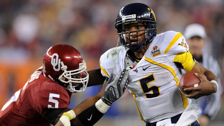 Jan 2, 2008; Glendale, AZ; USA; West Virginia Mountaineers quarterback Pat White (5) tries to break free from grasp of Oklahoma Sooners safety Nic Harris (5) in the second quarter in the Fiesta Bowl at University of Phoenix Stadium. Mandatory Credit: Kirby Lee/Image of Sport-USA TODAY Sports Jan 2, 2008; Glendale, AZ; USA; West Virginia Mountaineers quarterback Pat White (5) tries to break free from grasp of Oklahoma Sooners safety Nic Harris (5) in the second quarter in the Fiesta Bowl at University of Phoenix Stadium. Mandatory Credit: Kirby Lee/Image of Sport-USA TODAY Sports