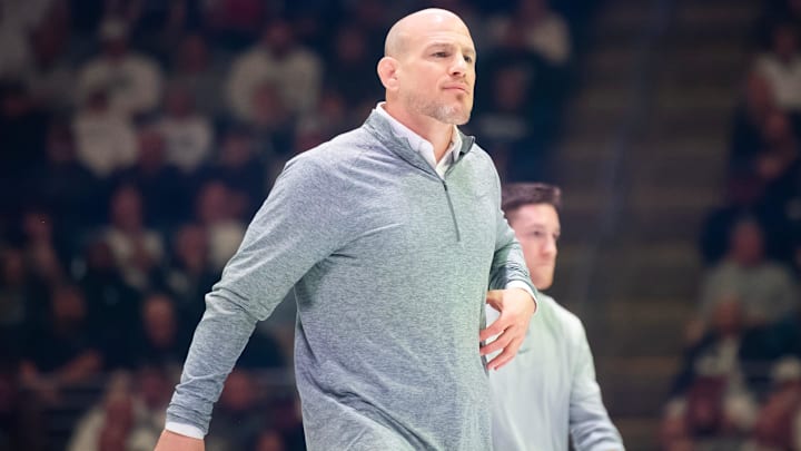 Penn State wrestling coach Cael Sanderson walks onto the mat  during a Nittany Lions match in State College.