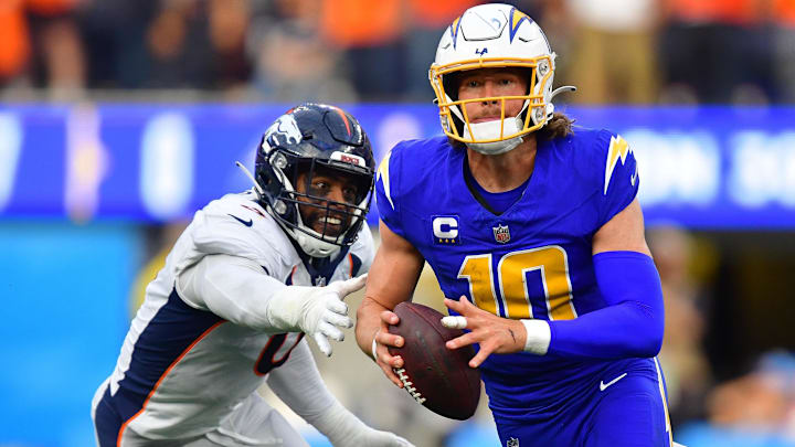 Dec 10, 2023; Inglewood, California, USA; Los Angeles Chargers quarterback Justin Herbert (10) moves out to pass against the defense of Denver Broncos linebacker Jonathon Cooper (0) during the first half at SoFi Stadium.