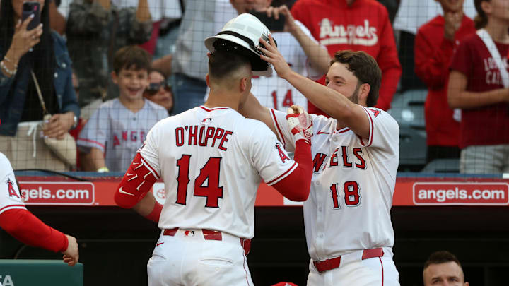Jun 21, 2025; Anaheim, California, USA; Los Angeles Angels first baseman Nolan Schanuel (18) present the fire helmet to catcher Logan O'Hoppe (14) after O'Hoppe hits a home run during the third inning against the Houston Astros at Angel Stadium. Mandatory Credit: Kiyoshi Mio-Imagn Images
