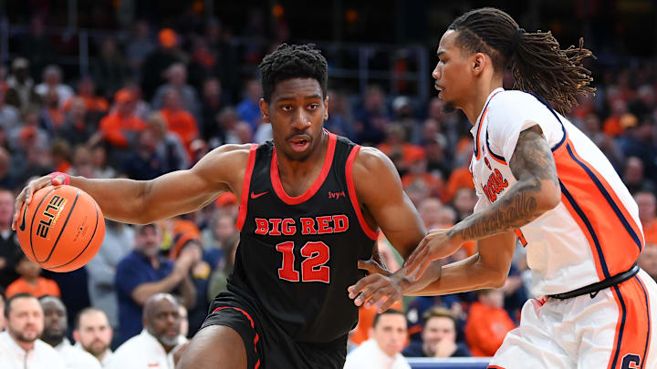 Nov 27, 2024; Syracuse, New York, USA; Cornell Big Red forward AK Okereke (12) drives against Syracuse Orange forward Chris Bell (4) during the first half at the JMA Wireless Dome. Mandatory Credit: Rich Barnes-Imagn Images